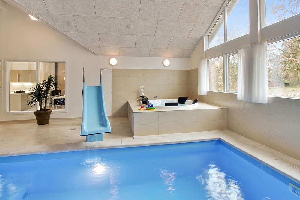 Både små och stora vattenälskare kan vältra sig i timmar i husets stora pool med motströmsanläggning och vattenrutschbana