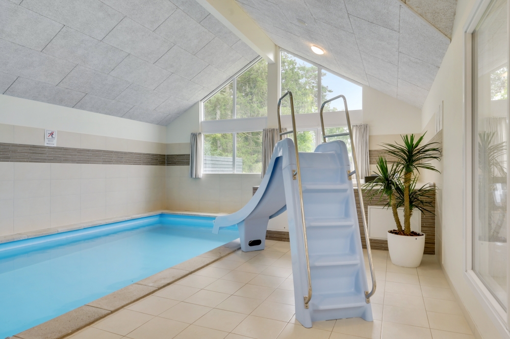 Sommarstuga 365 är inredd med en smakfull poolavdelning som har vattenrutschbana, ett stort inbyggt spapad och bastu