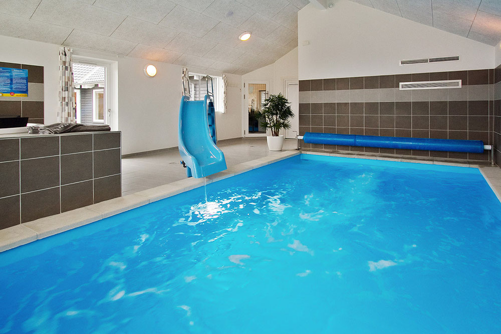 Sommarstuga 703 är inredd med en smakfull poolavdelning som har vattenrutschbana, ett stort inbyggt spapad och bastu