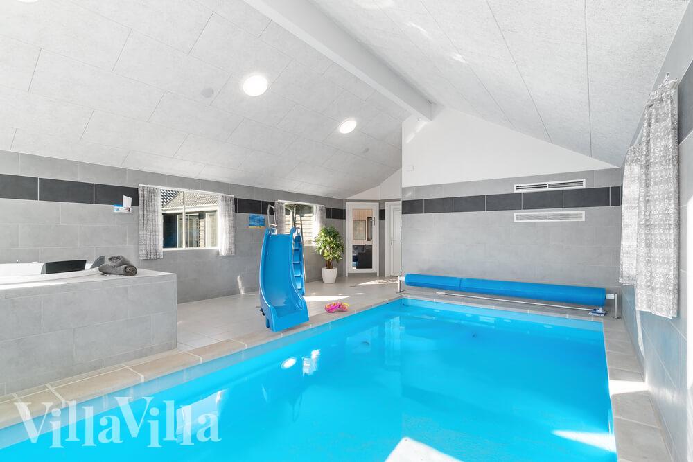 Sommarstuga 729 är inredd med en smakfull poolavdelning som har vattenrutschbana, ett stort inbyggt spapad och bastu