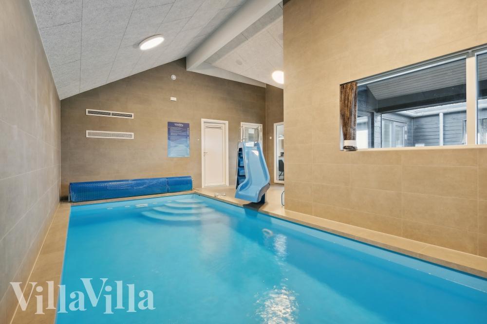 Sommarstuga 765 är inredd med en smakfull poolavdelning som har vattenrutschbana, ett stort inbyggt spapad och bastu