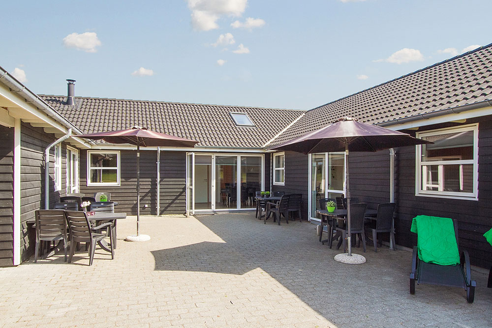 Husets gäster råder över en stor och delvis takbetäckt terrass med trädgårdsmöbler, liggstolar och grill