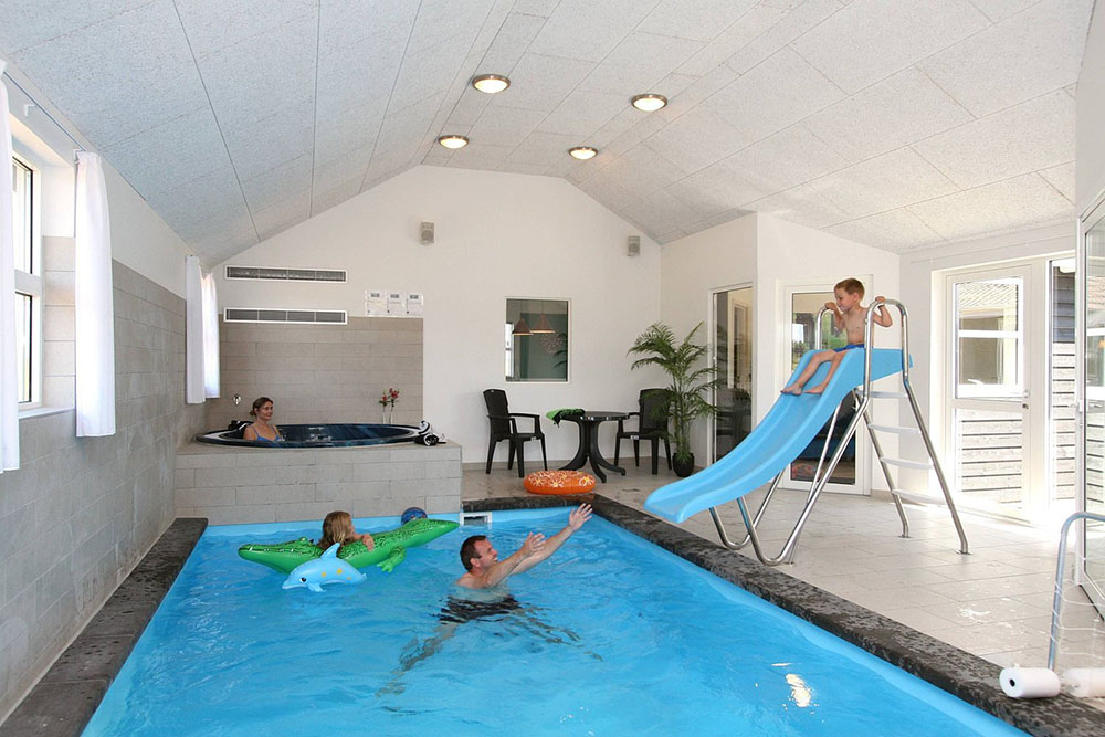 Det är bara att hoppa i – poolen på 21 m2 har undervattensbelysning, motströms-anläggning och rutschbana
