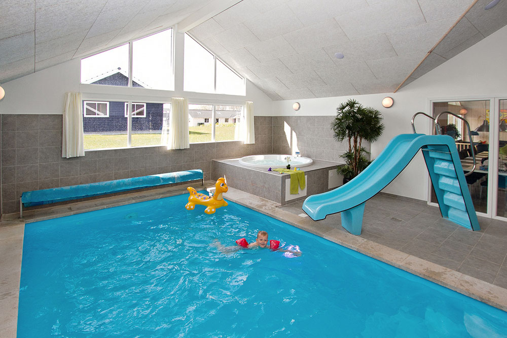 Både stora och små vattendjur kan roa sig i timvis i husets 19 m2 pool med romersk trappa och vattenrutschbana