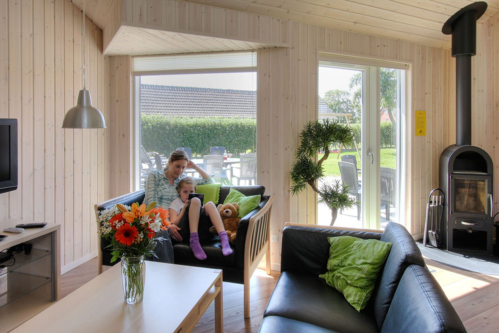 Komfortabla möbler, plattskärms-tv och kakelugn skapar en mysig och avslappnad miljö i huset