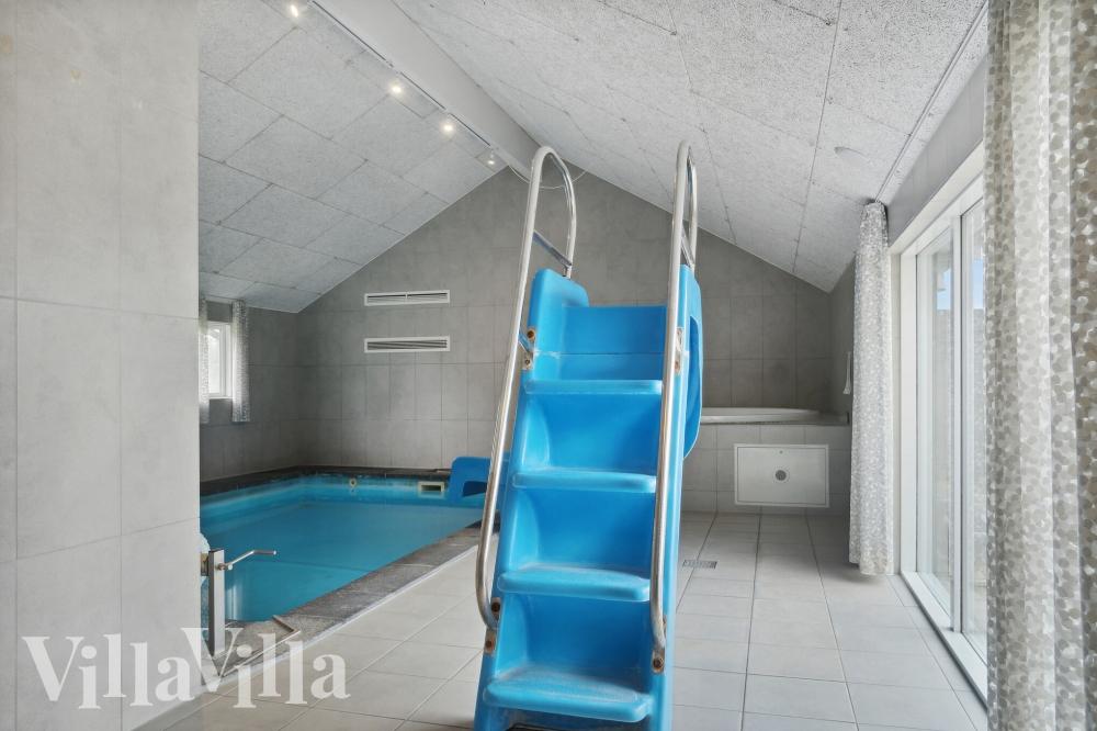 Sommarstuga 212 är inredd med en smakfull poolavdelning som har vattenrutschbana, ett stort inbyggt spapad och bastu