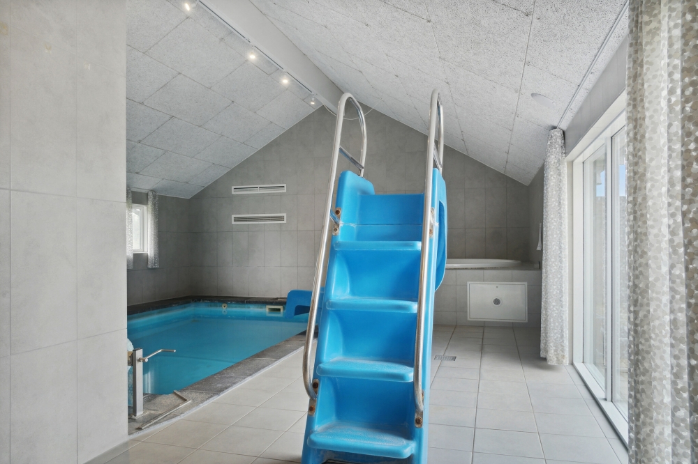 Sommarstuga 212 är inredd med en smakfull poolavdelning som har vattenrutschbana, ett stort inbyggt spapad och bastu